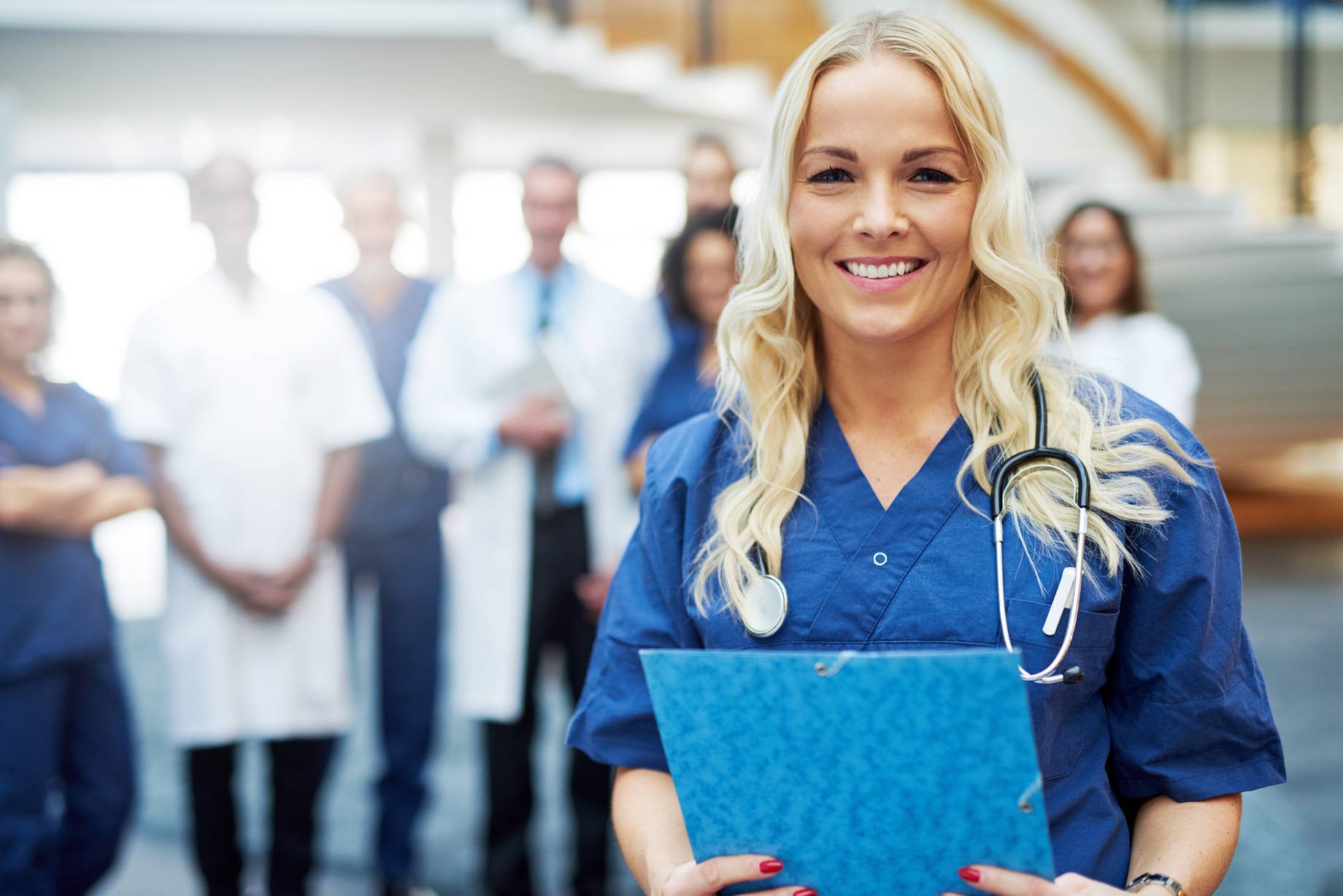 Cheerful blond medic with documents in hospital